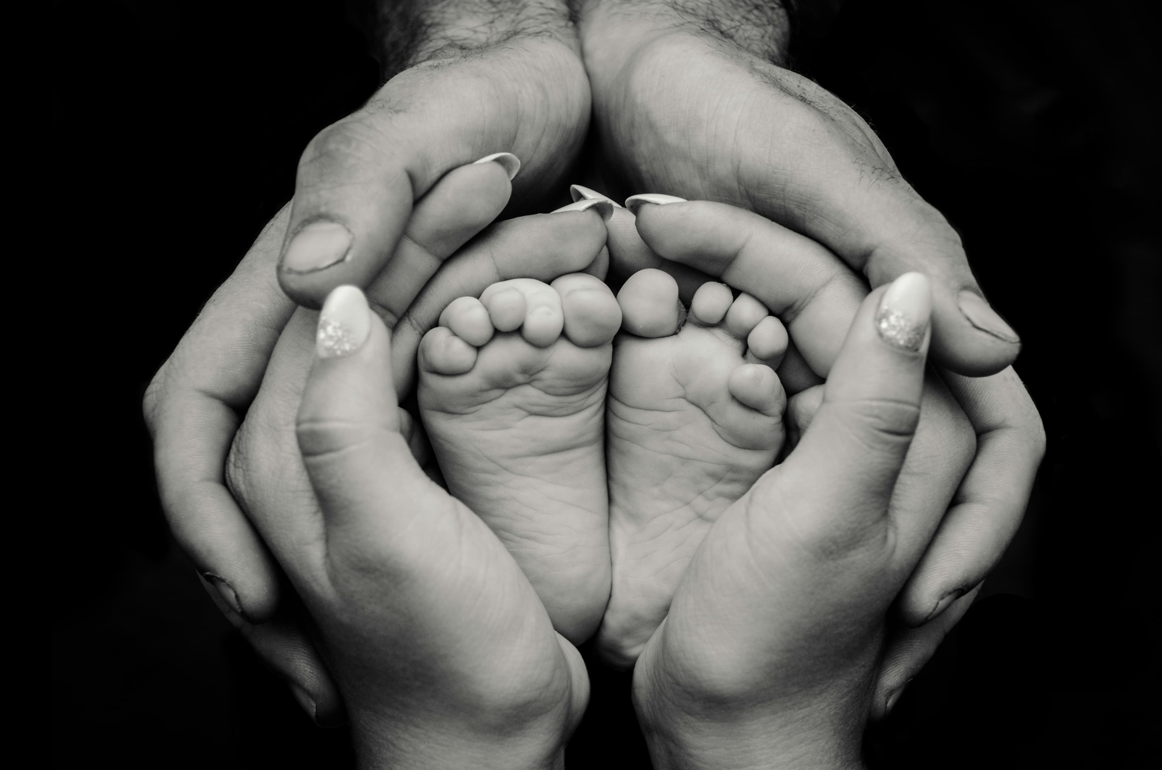 Hands cradling newborn feet, symbolizing care and new life at Nandi IVF